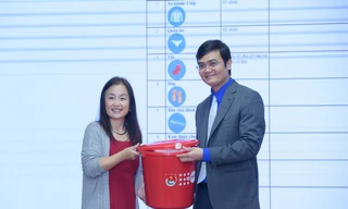 Anh Bùi Quang Huy tiếp nhận bộ đồ thiết yếu cho người cao tuổi ứng phó với lũ lụt từ bà Naomi Kitahara. Ảnh: Xuân Tùng