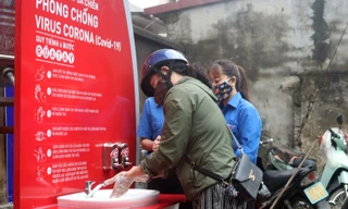 Đoàn viên thanh niên hướng dẫn người dân rửa tay đúng cách và tuyên truyền phòng chống dịch. Ảnh: TĐHG