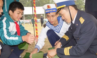 Cán bộ, chiến sĩ Lữ đoàn Hải quân đánh bộ 147 và các em học sinh cùng gói bánh chưng tặng người nghèo đón Tết. Ảnh: Nguyễn Minh.