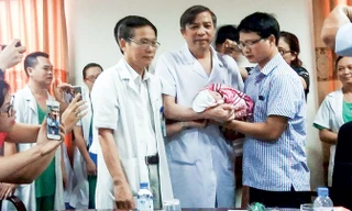 PGS.TS Vũ Bá Quyết, Giám đốc BV Phụ sản T.Ư trao bé Gấu cho người cha.