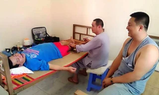 Anh Hùng (bìa phải) xem lương y chữa bệnh cho người dân.