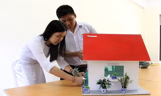 Quánh Đức Huy và Trần Mỹ Duyên với mô hình ngôi nhà giảm thiểu ô nhiễm môi trường cho khu dân cư lân cận bãi rác Khánh Sơn. Ảnh: Đào Phan.