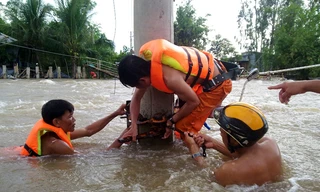 Công nhân Công ty Điện lực Đồng Tháp gia cố, bảo vệ lưới điện và thiết bị điện trong lũ. Ảnh: ĐLĐT.