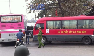 Xe khách dàn hàng ngang, đứng bắt khách trước cổng bến Giáp Bát sáng 13/2 nhưng cảnh sát chỉ đứng nhìn. Ảnh: Anh Trọng.