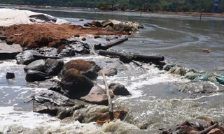 Nước rỉ đen ngòm từ túi bùn chảy về hướng vịnh Chân Mây.