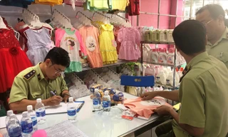 Lực lượng QLTT kiểm tra hàng hóa tại một cửa hàng Con Cưng. Ảnh: H.T.