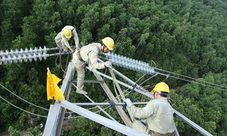 Ở độ cao khoảng 70m so với mặt đất, những người thợ truyền tải điện chỉ dùng chân và tay di chuyển dọc đường dây truyền tải điện để làm việc giữa trời nắng nóng.