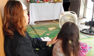 Vợ, con anh Điều trước bàn thờ chồng, cha.