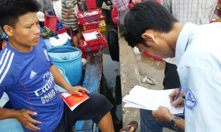 Cán bộ Chi cục Thủy sản TT-Huế ra tận tàu cá kiểm tra thủ tục và hướng dẫn ngư dân kê khai thông tin cấp chứng nhận thủy sản an toàn. Ảnh: Ngọc Văn.