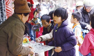 Học sinh tiểu học ở Hà Nội đang mua miếng dán độc hại có xuất xứ Trung Quốc trước cổng trường. Ảnh: Như Ý.