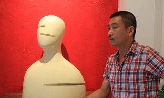 Lê Thiết Cương và “Chân dung 2” - tác phẩm trong triển lãm điêu khắc Mặt của anh. Ảnh: N.M.Hà.