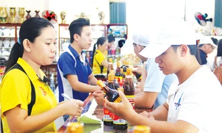 Người tiêu dùng mua nước mắm Phú Quốc trở lại. Ảnh: Huy Hải.