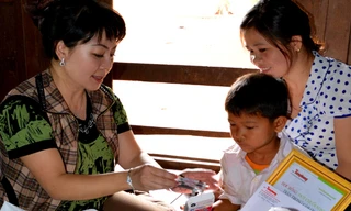 Tác giả trao quà và học bổng cho một học trò mồ côi mắc bệnh hiểm nghèo.