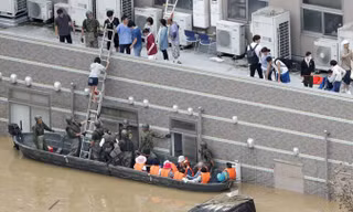 Các lực lượng phòng vệ đưa người dân ra khỏi vùng lụt tại tỉnh Okayama. Ảnh: Kyodo.