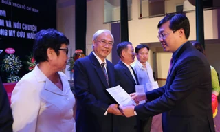 Anh Lê Quốc Phong trao sổ tiết kiệm cho các cựu TNXP. Ảnh: Như Ý.