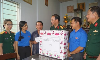 Thượng tá Ðinh Quốc Hùng, Trưởng ban Thanh niên Quân đội thăm hỏi, tặng quà cho thương binh Nguyễn Văn Chuyên. Ảnh: N.M.