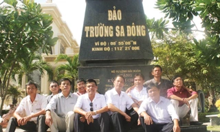 Những cựu binh Trường Sa nhiều thế hệ cùng ngồi bên mô hình cột mốc chủ quyền do anh Trần Văn Xuất làm ngay tại nhà mình. Ảnh Nguyễn Thành.