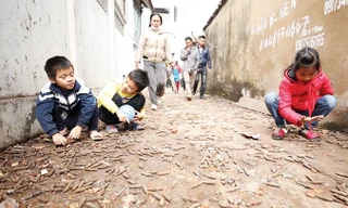 Trẻ em vẫn vô tư nhặt đạn được rải như vãi thóc trên đường làng Quan Độ (xã Văn Môn, huyện Yên Phong, Bắc Ninh) sau vụ nổ. Ảnh: Phạm Tuấn.