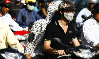 Người dân Hà Nội ra đường phải đối phó với khói bụi. Ảnh: Hồng Vĩnh.