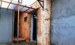 Chủ thuê chỉ mới cho tô trát vữa mới “lấy lệ” ở phần tường nhỏ phía trước, còn mặt sau vẫn để nguyên như sau khi vừa bị tẩy phá.