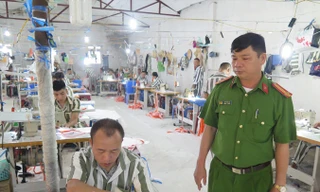 Trung tá Lâm Văn Lợi cùng các phạm nhân làm việc tại xưởng may.