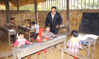 Thầy giáo Lô Văn Lan dạy chữ cho học trò bản Huồi Máy.