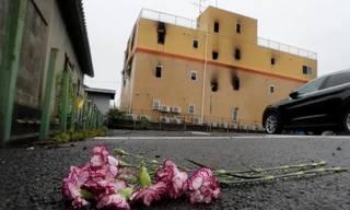 Một số người đã tới đặt hoa tưởng niệm các nạn nhân bên ngoài tòa nhà bị cháy. Ảnh: Reuters ​