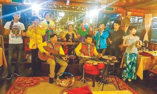 Tác giả bài viết đánh đàn ghi ta trên thuyền phục vụ khách du lịch trên sông Sài Gòn 