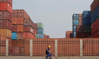 Công nhân đi ngang một trung tâm kho vận ở cảng Thiên Tân, Trung Quốc hôm 16/5. Ảnh: Reuters