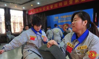 Thiếu nữ Trung Quốc tay trần bò trên đá học làm vệ sỹ