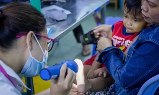 Bác sĩ khám bệnh tay chân miệng cho trẻ tại Khoa Nhiễm, Bệnh viện Nhi đồng 1. Ảnh: Thành Nguyễn. 