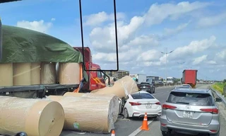Nhiều cuộn giấy trên xe đầu kéo rơi xuống đường, đè trúng ô tô con