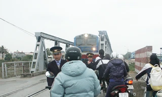 Nhân viên gác tàu ở cầu Tam Bạc cố ngăn cậu thanh niên vượt vì tàu đang đến gần