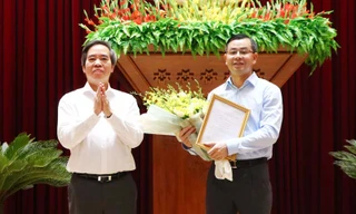 Đồng chí Nguyễn Văn Bình trao quyết định và chúc mừng đồng chí Ngô Văn Tuấn. 