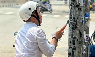 Dán quảng cáo lên cột điện TPHCM, người vi phạm bị bắt đi cạo bỏ