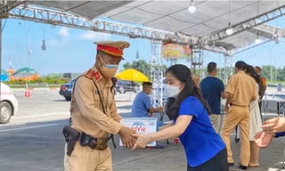 Chị Chu Hồng Minh, Bí thư Thành Đoàn Hà Nội trao tặng nước uống cho lực lượng trực tại các đểm chốt kiểm soát của Thủ đô