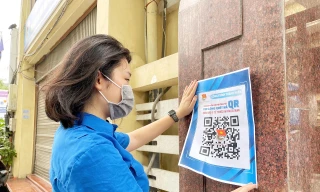 Chị Nguyễn Mai Anh, Phó Bí thư Đoàn cơ quan, Bí thư Chi đoàn Văn phòng Thành Đoàn Hà Nội dán mã QRcode tại cổng Thành Đoàn Hà Nội.