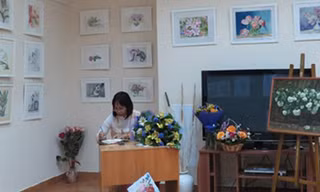Một góc triển lãm tranh của Thúy Quỳnh và một khán giả đang viết những dòng cảm xúc về tranh của Thúy Quỳnh
