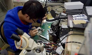 Một thợ sửa điện thoại tiến hành nâng cấp bộ nhớ trong iPhone. Nguồn: CCTV