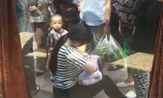 Hình ảnh người phụ nữ trẻ cho em bé bú trên vỉa hè được nhiều người ca ngợi. Ảnh: Shanghaiist.