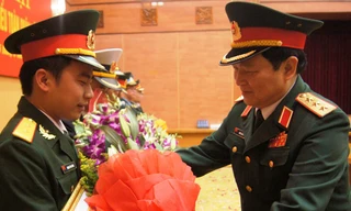 Thượng tướng Ngô Xuân Lịch (bên phải), Bí thư T.Ư Đảng, Chủ nhiệm Tổng cục Chính trị trao bằng khen và tặng hoa chúc mừng Trung úy Hoàng Văn Đông, tháng 3/2014. ảnh: NGUYỄN MINH