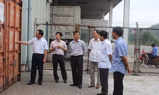 Phó Chủ tịch UBND tỉnh Quảng Ninh Đặng Huy Hậu (ngoài cùng bên trái) tại hiện trường lưu giữ hai container chứa dầu biến thế nhiễm PCB tại cảng Cái Lân. Ảnh: Đỗ Hoàng