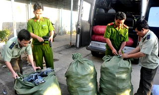 Các cơ quan chức năng kiểm tra các bao hàng chứa súng nhựa trên xe chở khách. Ảnh: VnExpress
