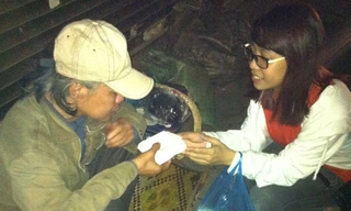 Sinh viên CLB Kỹ năng sống trường Đại học Ngoại thương tặng xôi cho bà cụ trên đường phố Hà Nội đêm 30/4. Ảnh: Hữu Thắng