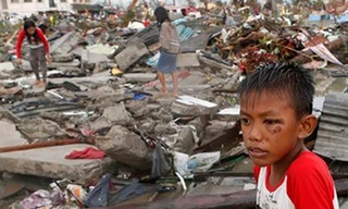 Em bé ngồi thẫn thờ giữa cảnh đổ nát hoang tàn sau siêu bão Hải Yến ở Philippines