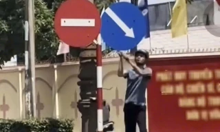 Công an làm việc với người đàn ông cầm búa đập biển báo giao thông trên phố