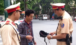 Lực lượng CSGT nhắc nhở người tham gia giao thông phải đội mũ bảo hiểm đạt chuẩn. Ảnh: Tuấn Nguyễn