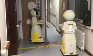 Nhiều nhà khoa học đề xuất việc sử dụng robot hỗ trợ bệnh viện trong việc đưa cơm, nước, lau sàn, khử khuẩn. Ảnh minh họa: Robot phục vụ tại một bệnh viện ở Thâm Quyến, Trung Quốc.