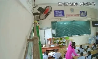 Cô giáo đang véo tai một học sinh