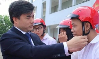 Ông Bùi Văn Linh tặng mũ bảo hiểm cho học sinh.